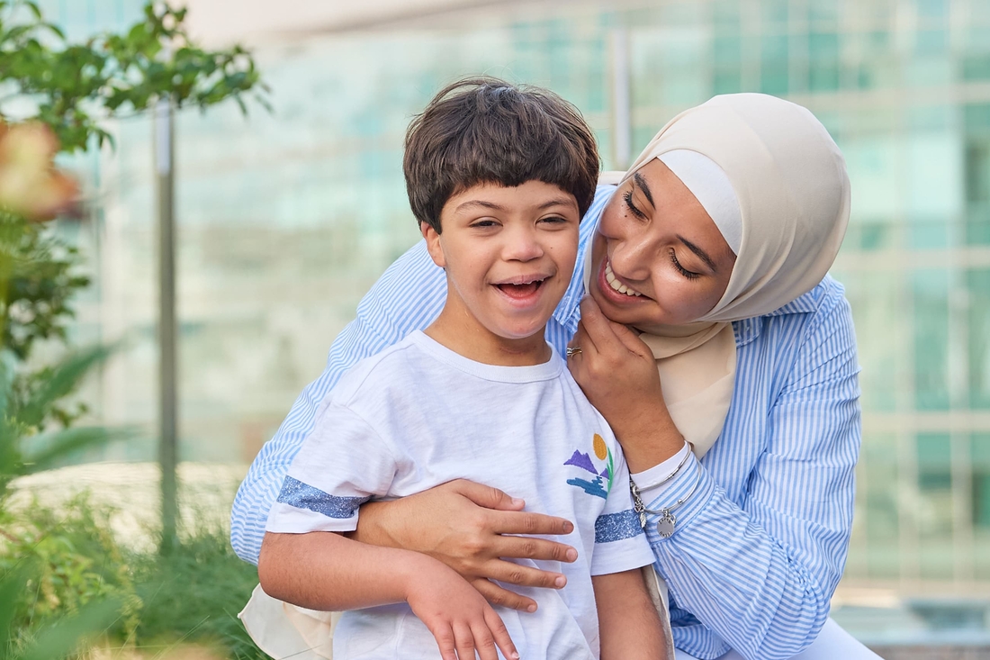 Middle eastern boy smiling with his muslim mom in the hospital garden