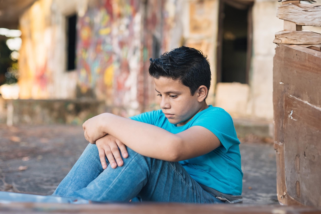 Young boy sitting on the ground