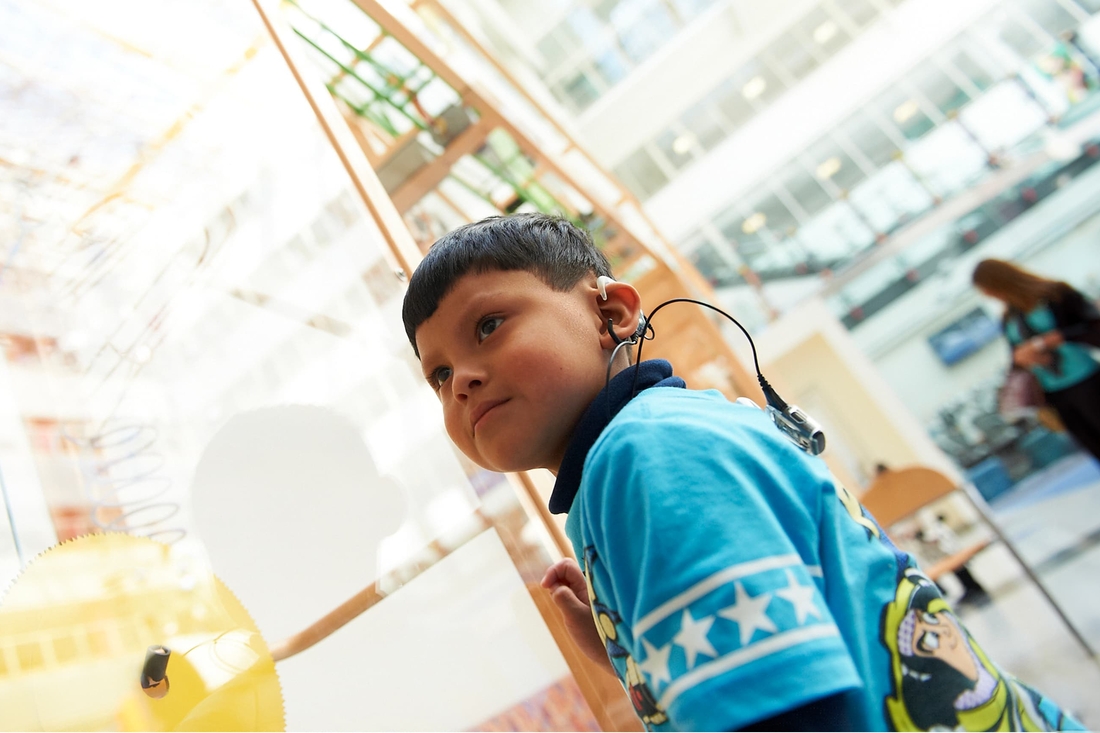 Young boy with audio device in main lobby of Childrens Hospital of Philadelphia