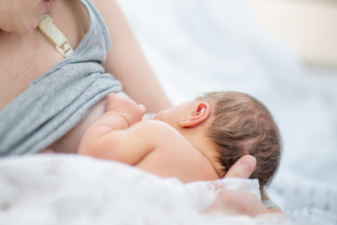 A new mother gets the assistence she needs to nurse her newborn baby