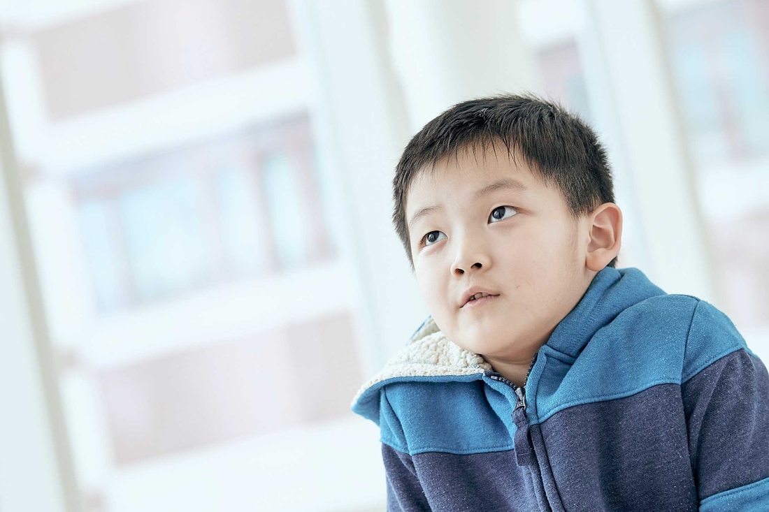 Boy in striped sweatshirt in a CHOP hallway