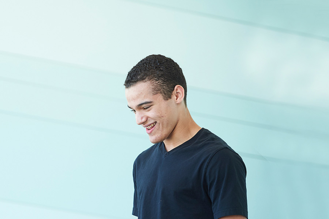 Teen boy looking down and smiling