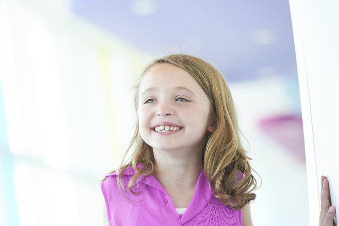 Girl in pink shirt smiling.