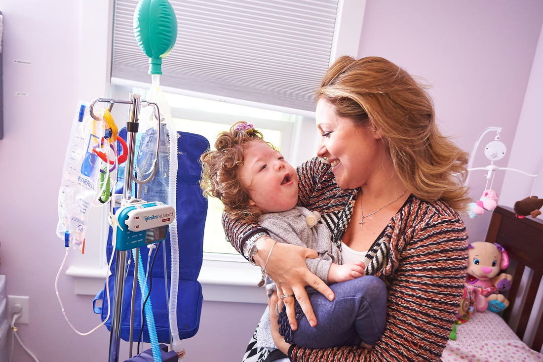 Mom holding her special needs child at home