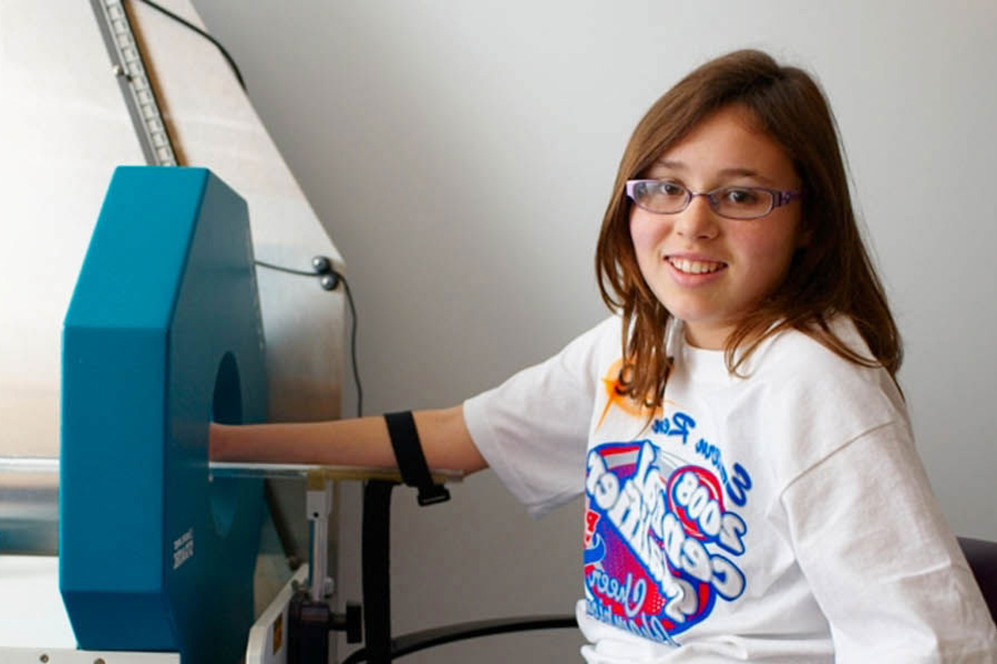 Girl getting arm X-ray and smiling at the camera.