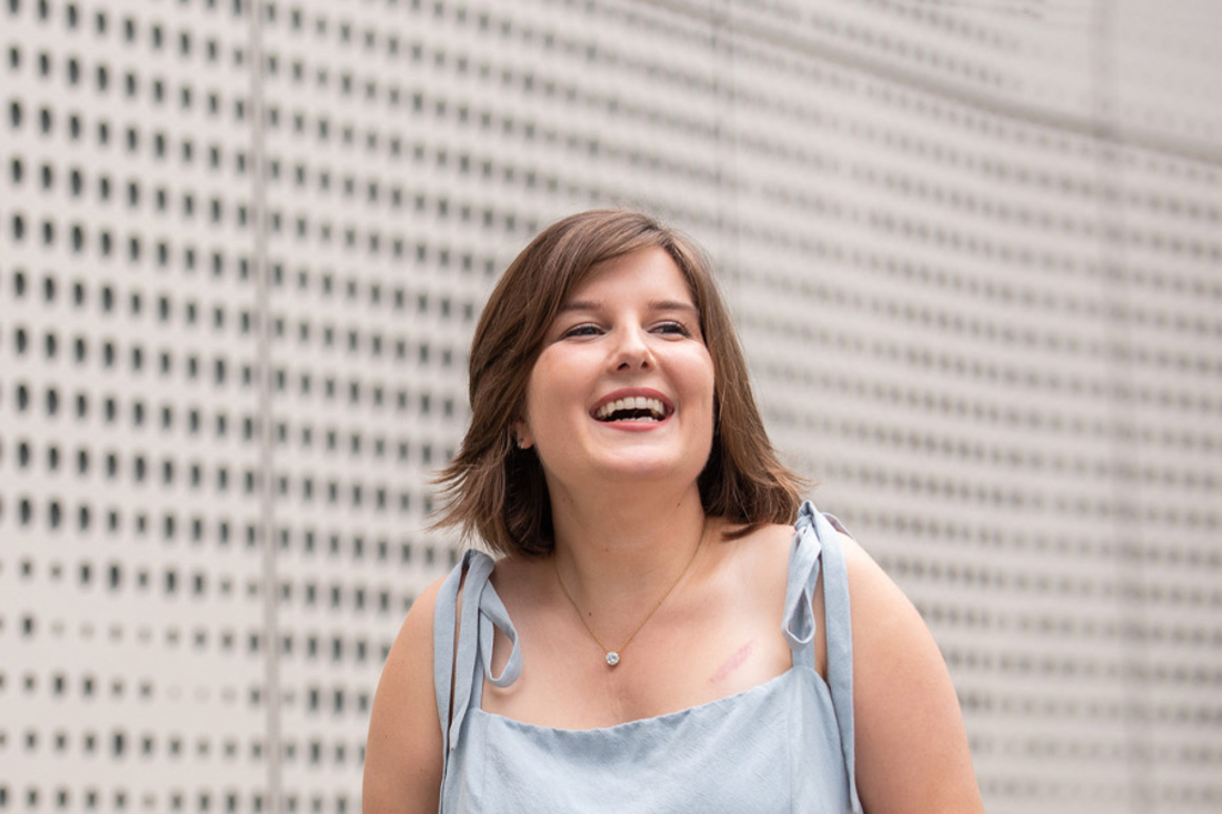 Young woman with shoulder length brown hair smiles.