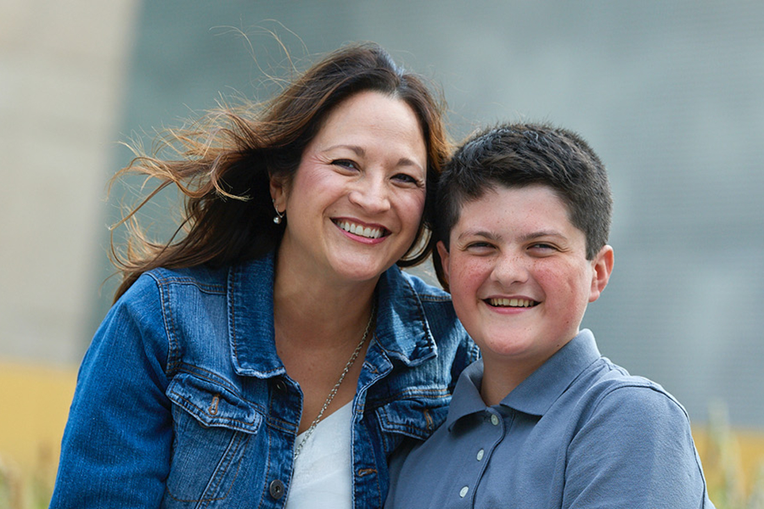 Mom and her pre-teen son smiling at the camera.