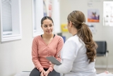 teenage girl facing doctor in an office