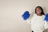 African american adolescent girl wearing a white sweater while she cheers and smiles
