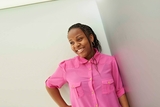 teen girl leaning against wall smiling