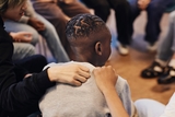 Young boy in a group setting is comforted