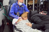 Mommy leans down to kiss her small child in an emergency transort moment