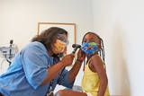 Doctor performing checkup on patient in exam room