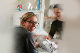 Smiling staff member stops by a patient's bedside