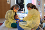 A baby well looked after by two of our NICU staff members