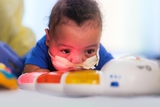 Baby doing tummy time with sound and light toy