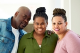 parents smiling with their daughter that has a heart transplant scar.