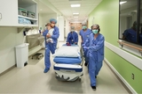 Surgical team transporting young child to surgery