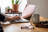 Hands typing at a laptop computer