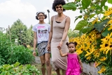 Happy parent and children walking in a garden.
