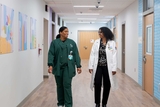 Two staff members walking down a hallway