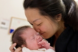 Mom carrying baby and smiling 