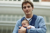 Young dad carrying baby