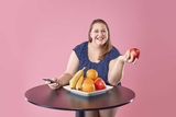 Dietician smiling with a bowl of fruit.