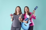 Two staff members with musical instruments, smiling.