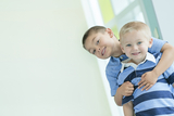Brothers smiling at the camera and hugging