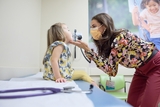 Doctor doing an exam to his young female patient.