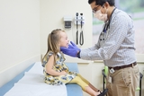 Doctor doing an exam to his young female patient.