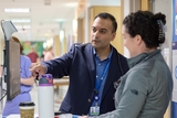 Doctor pointing at a screen while talking to his colleague.