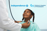 Girl looking up at a healthcare professional who is holding a stethoscope.