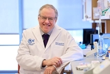 Dr. Grupp wearing a white coat in a lab