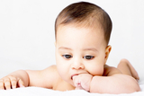 Teething baby chewing on hand