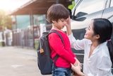 Mother with son holding backpack