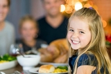 Young girl smiling at Thanksgiving table Young girl smiling at Thanksgiving table