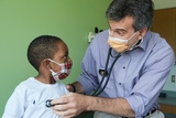 Doctor listening to young boy's heartbeat Doctor listening to young boy's heartbeat