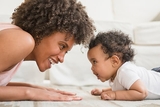 Mother playing with young toddler on the floor