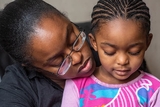 Mother holding daughter close