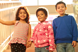 three children holding hands and smiling