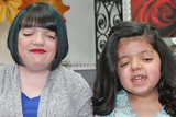 Two girls smiling with new haircuts Two girls smiling with new haircuts