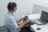 Teenager using a steering wheel for a safe driving simulator