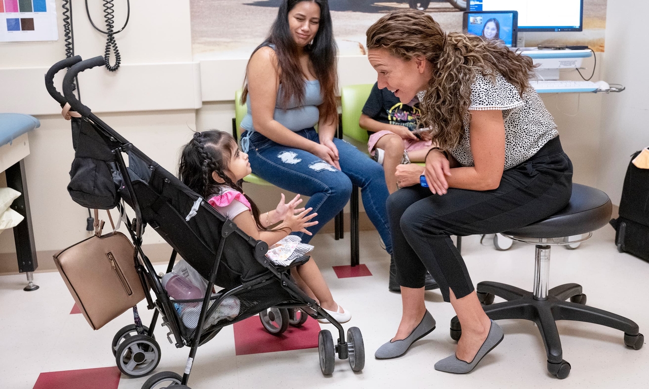 Alexa, 4, and her mother, Alejandra, meet with McKenzie in the Seating Clinic. Alexa’s genetic condition has weakened her legs. She is being fitted for a wheelchair so she can learn to propel herself.