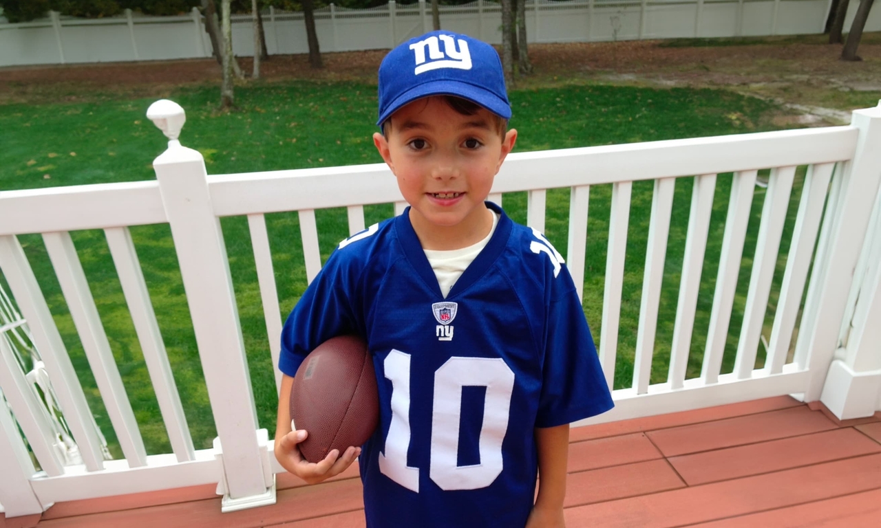 Antonio has a young boy holding a football