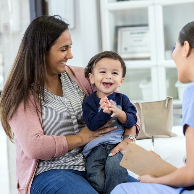 Young boy at a doctor office sitting on his mothers lap