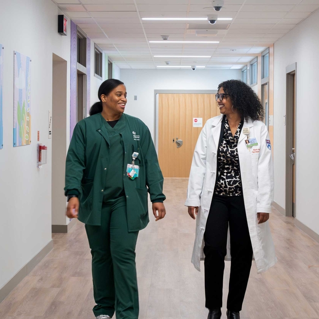Two staff members walking down a hallway