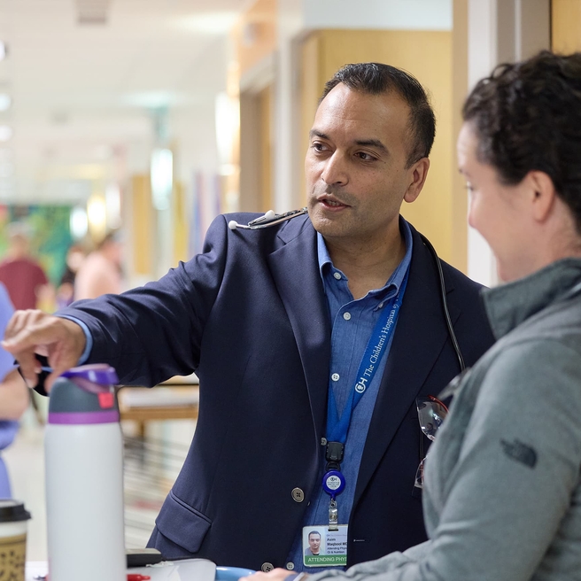Doctor pointing at a screen while talking to his colleague.