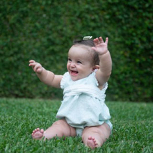 baby sitting in grass laughing